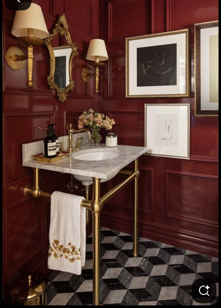 elegant bathroom with a sink with brass console sink with red walls and marbre sink