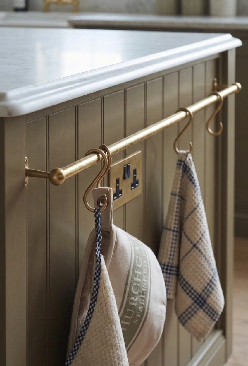 rod made of brass in aged brass finish used as a pot and pans rack installed on a white wall 