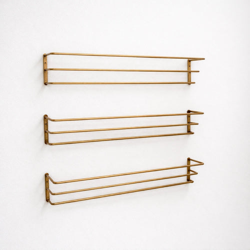 Brass bottle holder with a polished finish, designed to securely store and display bottles while adding an elegant and functional touch to bars, countertops, or kitchen spaces.