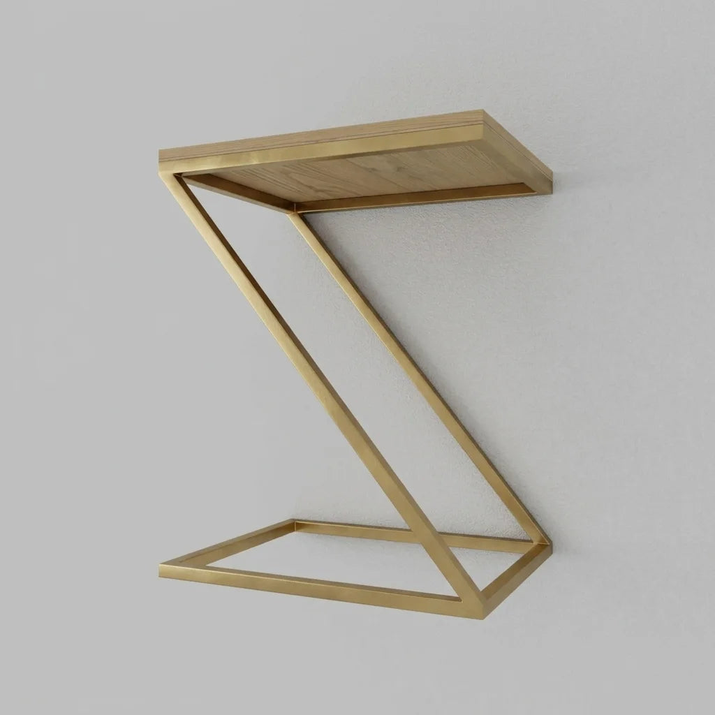 A modern Z-shaped side table with a brushed gold metal frame and a light wood top, shown against a neutral light gray background.