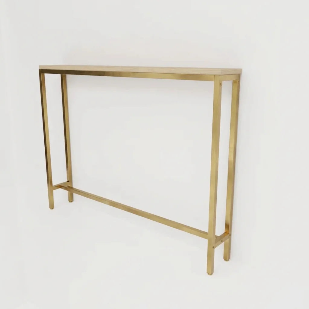 A minimalist console table with a slim rectangular gold metal frame and a light wood top, shown against a plain white background.