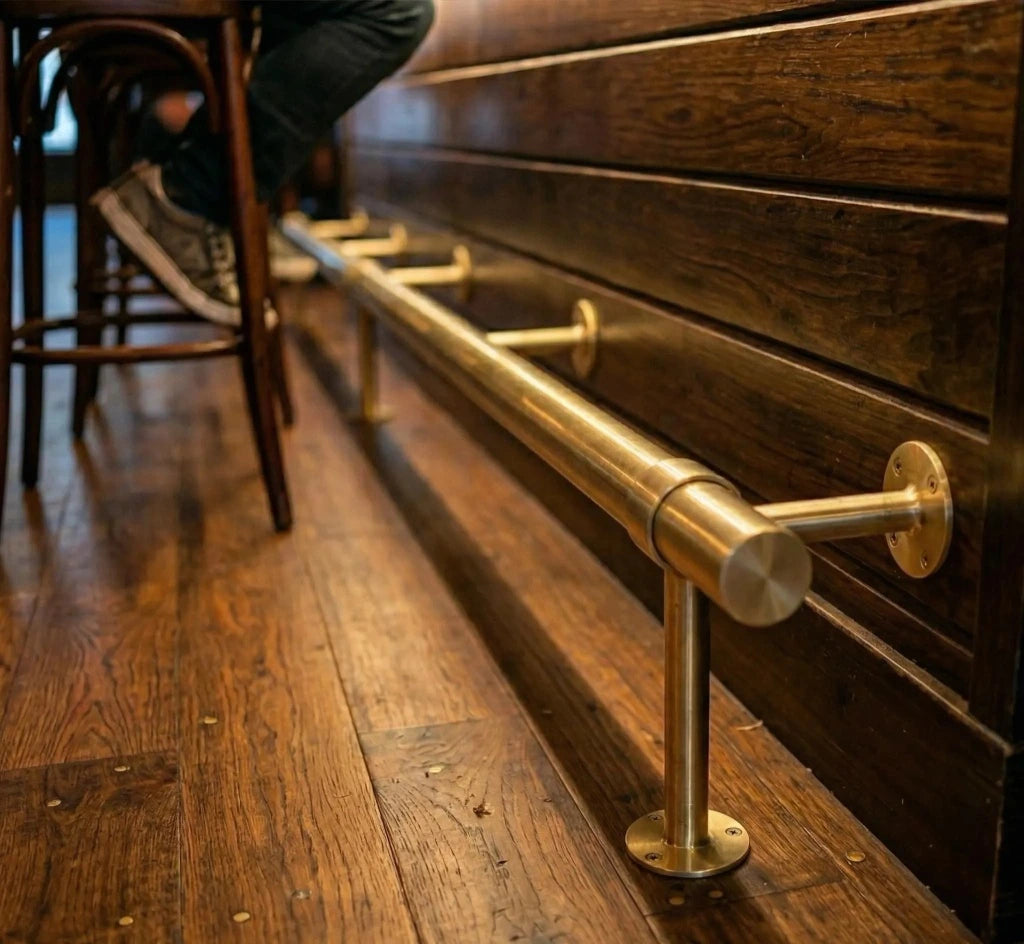 Brass Bar Footstoo installed in a bar next to bar chairs 