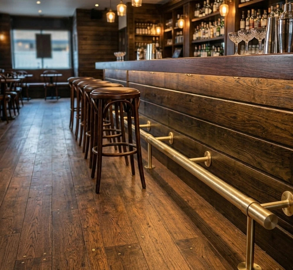 Brass Bar Footstoo installed in a bar next to bar chairs in a cosy bar 