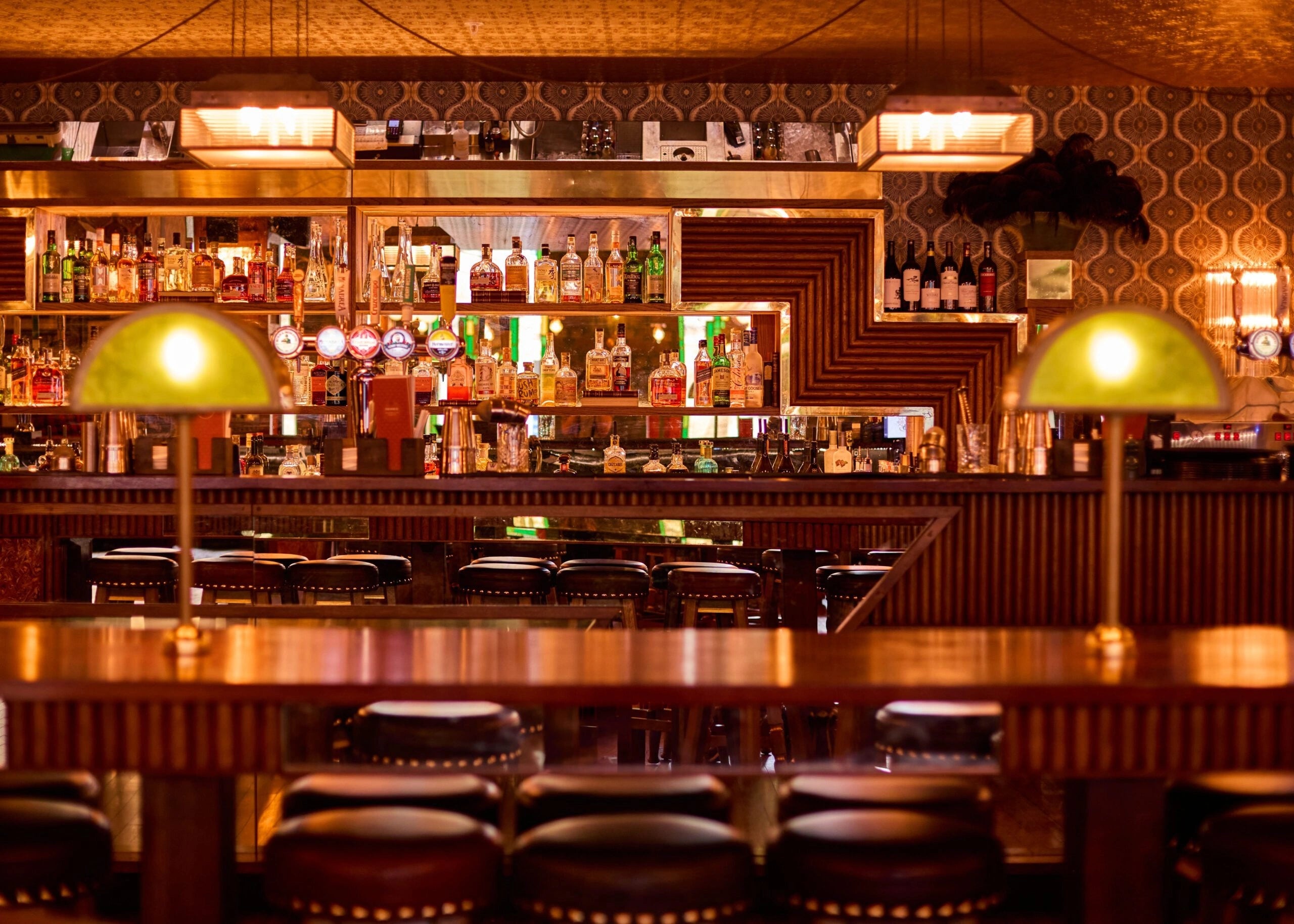 cosy and warm ambiance in a bar with wine bottles in the back of the bar 