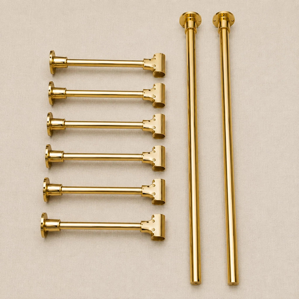 Six gold-finished metal curtain rods arranged on a light beige background, including four horizontal rods with finials, two vertical rods with finials, and two shorter vertical rods.