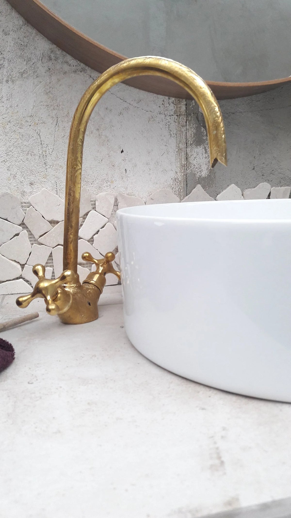 brass engraved solid goosneck faucet on a table next to a white ceramic sink and a mirror 
