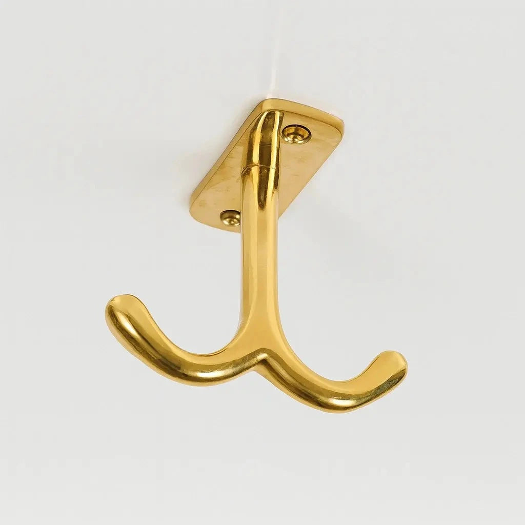 Brass ceiling double hook with a polished finish, designed for overhead installation to securely hang coats, bags, or accessories while maintaining a sleek and space-saving look. 