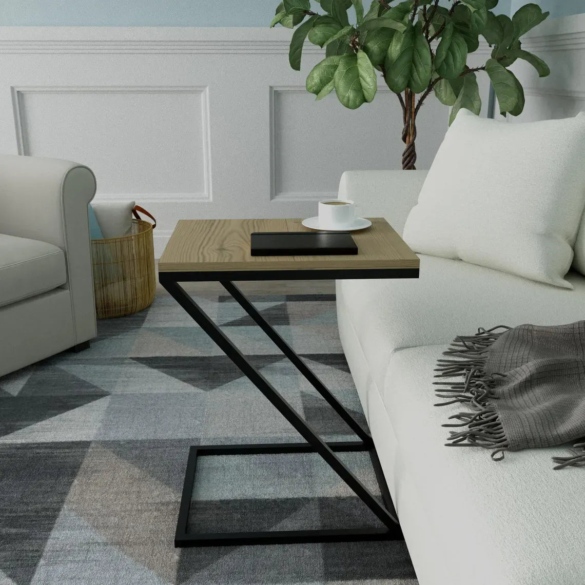 A modern side table with a light wood top and black metal frame, styled in a living room next to a white sofa with a cup of coffee on top.